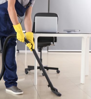 Janitor,Hoovering,Floor,In,Office